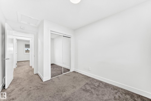 Interior room featuring neutral carpeting, white walls, and a sliding mirrored closet door - 17 4137 76 Street, Edmonton, AB 