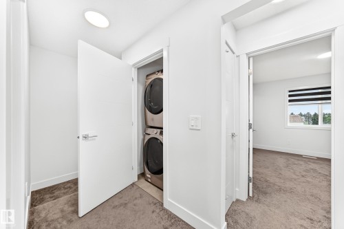 Dedicated laundry closet featuring a stacked washer and dryer - 17 4137 76 Street, Edmonton, AB 