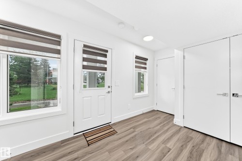 Light wood-finish flooring complements the bright white walls and trim - 17 4137 76 Street, Edmonton, AB 