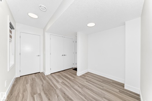 Room featuring recessed lighting, wood-finish flooring, white walls, and white trim - 17 4137 76 Street, Edmonton, AB 