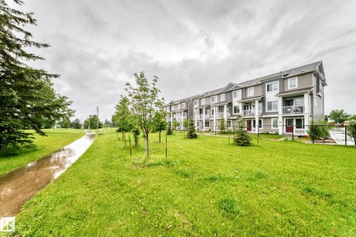 Multi-story townhome residences featuring balconies with white railings and red entry doors - 17 4137 76 Street, Edmonton, AB 