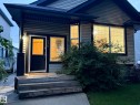 Exterior featuring horizontal siding, a dark trim entry door, and a front window with horizontal blinds - 1978 Tomlinson Green Green, Edmonton, AB 