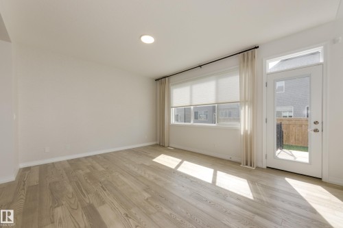 Open interior space featuring wood-finish flooring, recessed ceiling lighting, and a white color palette - 3249 Dixon Way, Edmonton, AB 
