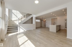 Spacious interior featuring light wood-finish flooring and white walls - 