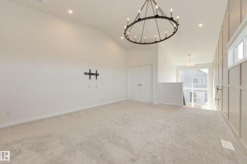 Open loft area featuring a vaulted ceiling with recessed lighting and a large wagon wheel chandelier - 3249 Dixon Way, Edmonton, AB 