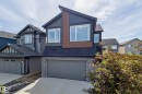Contemporary two-story exterior featuring dark siding with wood-tone accents - 3249 Dixon Way, Edmonton, AB 