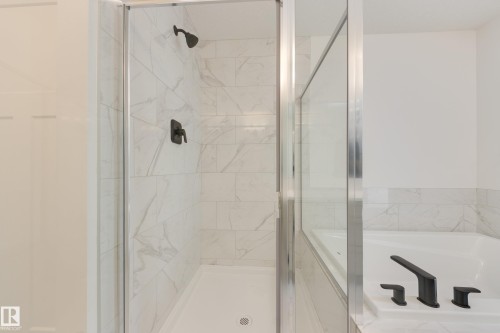 Contemporary shower enclosure featuring clear glass panels and a matte black showerhead - 3249 Dixon Way, Edmonton, AB 