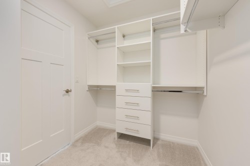 Built-in closet organization system featuring shelving, multiple hanging rods, and pull-out drawers - 3249 Dixon Way, Edmonton, AB 