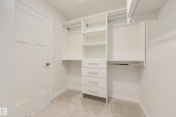 Built-in closet organization system featuring shelving, multiple hanging rods, and pull-out drawers - 