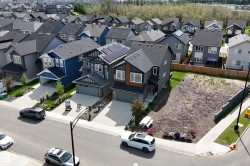 Spacious corner lot with a level grade, bordered by a sidewalk and street - 