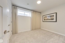 Carpeted room featuring a white paneled door, a horizontal window with drapes, and recessed lighting - 