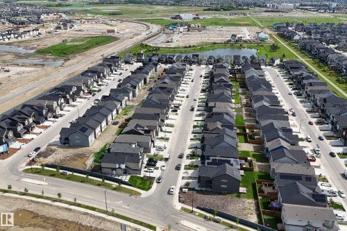 Aerial overview of a residential development featuring numerous single-family homes with dark roofs - 3249 Dixon Way, Edmonton, AB 