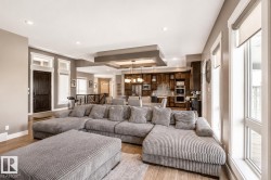 Open-concept living space featuring wood-finish flooring, recessed lighting, and a tray ceiling - 