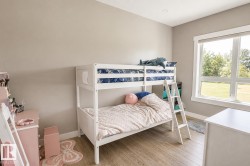 Neutral-toned room featuring light wood-finish flooring, a large window with white trim, and recessed lighting - 