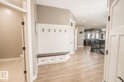 Entryway featuring wood-finish flooring, recessed lighting, and a built-in bench with storage drawers and coat hooks - 