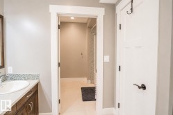 Bathroom vanity with a white oval sink, chrome faucet, and mosaic tile backsplash - 