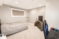Carpeted room featuring a white drop ceiling with recessed lighting - 