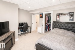 Carpeted room featuring light gray walls, white trim, recessed lighting, and a white paneled door - 