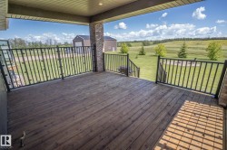 Covered wood-finish deck with black metal railing - 