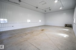 Spacious concrete floor with white paneling walls and ceiling - 