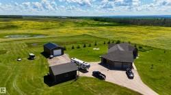 Expansive green property featuring a multi-gabled main residence, detached garage, and an additional outbuilding - 