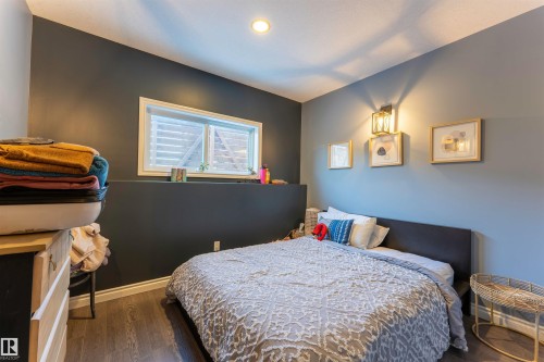 Bedroom featuring wood-finish flooring, recessed ceiling lighting, and a wall-mounted sconce - 4804 64 Avenue, Cold Lake, AB 
