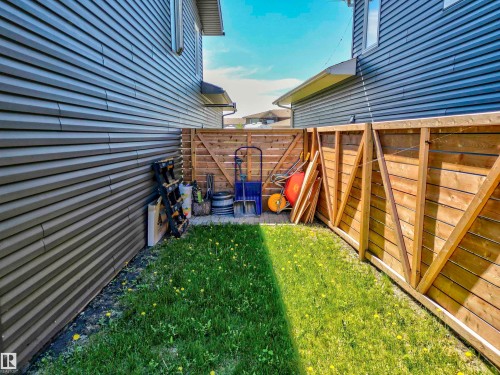 Fenced side yard featuring a grass lawn, privacy fencing, and horizontal siding - 4804 64 Avenue, Cold Lake, AB 