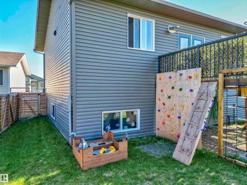 Exterior featuring horizontal gray siding, a second-story deck with black metal railing, and a ground-level window - 4804 64 Avenue, Cold Lake, AB 