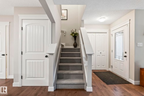 Staircase with carpeted treads and white wood-finish balusters - 1542 33A St Nw, Edmonton, AB 