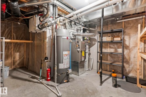 Utility space featuring a water heater, furnace, and exposed ductwork - 1542 33A St Nw, Edmonton, AB 
