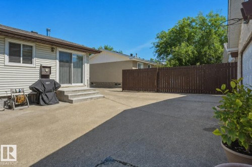 Expansive concrete patio with direct outdoor access via sliding glass doors - 8901 94 Avenue, Fort Saskatchewan, AB 