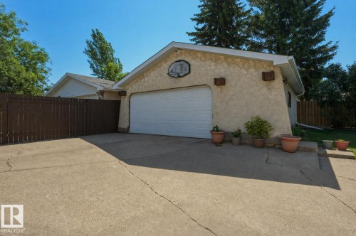 Detached garage featuring stucco exterior, white garage door, and a concrete driveway - 8901 94 Avenue, Fort Saskatchewan, AB 