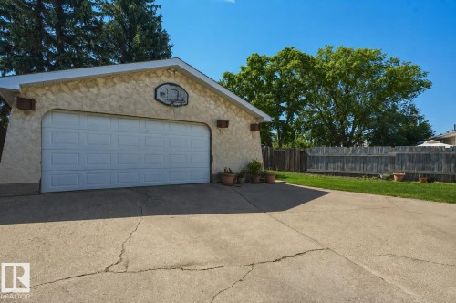 Detached garage featuring a paneled overhead door, stucco exterior, and gable roofline - 8901 94 Avenue, Fort Saskatchewan, AB 