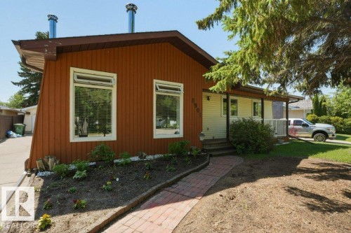 Contemporary home exterior featuring a front porch, brick pathway, and a landscaped garden bed - 8901 94 Avenue, Fort Saskatchewan, AB 