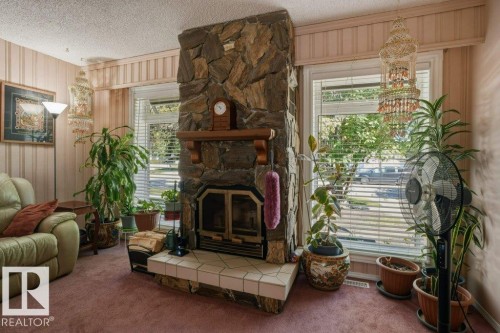 Stone-clad fireplace with a wood mantel and tile hearth - 8901 94 Avenue, Fort Saskatchewan, AB 