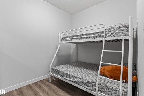 Neutral wall color with wood-finish flooring and white trim - 8046 Kiriak Link, Edmonton, AB - Indoor Photo Showing Bedroom