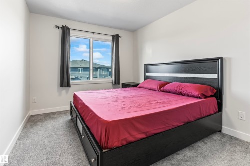 Carpeted room with a large window and white trim - 8046 Kiriak Link, Edmonton, AB - Indoor Photo Showing Bedroom
