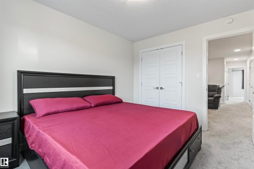 Light-colored walls, patterned carpet flooring, and white trim throughout - 8046 Kiriak Link, Edmonton, AB - Indoor Photo Showing Bedroom