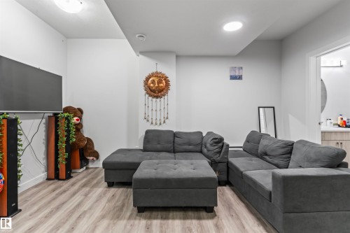 Spacious room featuring wood-finish flooring, recessed lighting, and a white color palette - 8046 Kiriak Link, Edmonton, AB - Indoor Photo Showing Living Room