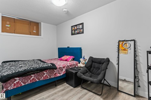 Room featuring light gray walls, wood-finish flooring, and a flush-mount ceiling light - 8046 Kiriak Link, Edmonton, AB - Indoor Photo Showing Bedroom