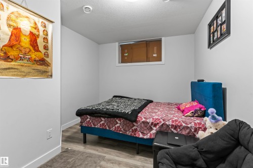 Room featuring light gray walls, wood-finish flooring, and white trim - 8046 Kiriak Link, Edmonton, AB - Indoor Photo Showing Bedroom