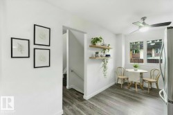 Contemporary interior featuring wood-finish flooring, white walls, and a multi-pane window - 