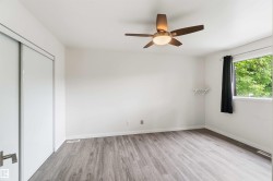 Bright room featuring wood-finish flooring and a ceiling fan with integrated lighting - 