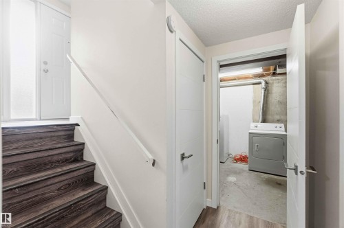 Dark wood-finish stairs with white risers and a white handrail - 3312 106 Avenue, Edmonton, AB 