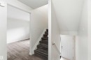 Interior staircase featuring wood-finish treads and risers with a white handrail - 3312 106 Avenue, Edmonton, AB 