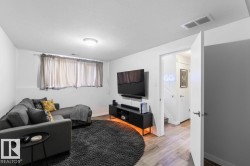 Finished lower level featuring recessed lighting, light wood-finish flooring, and white walls - 