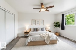 Spacious room featuring wood-finish flooring, a contemporary ceiling fan with integrated lighting, a large window providing natural light, and a built-in closet with sliding doors - 