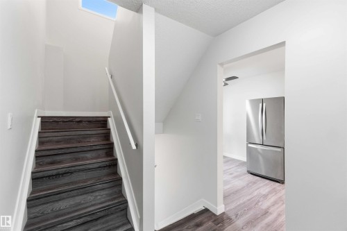 Modern staircase with dark wood-finish treads and white risers - 3312 106 Avenue, Edmonton, AB 