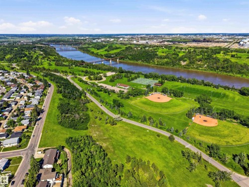 Expansive green spaces bordering a river, featuring two baseball diamonds, tennis courts, and walking paths - 3312 106 Avenue, Edmonton, AB 