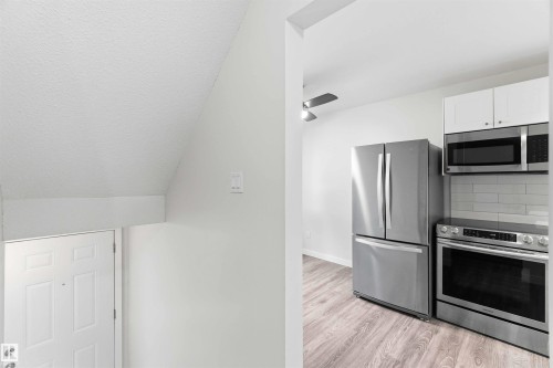 Contemporary kitchen featuring stainless steel appliances, white cabinetry, and a subway tile backsplash - 3312 106 Avenue, Edmonton, AB 